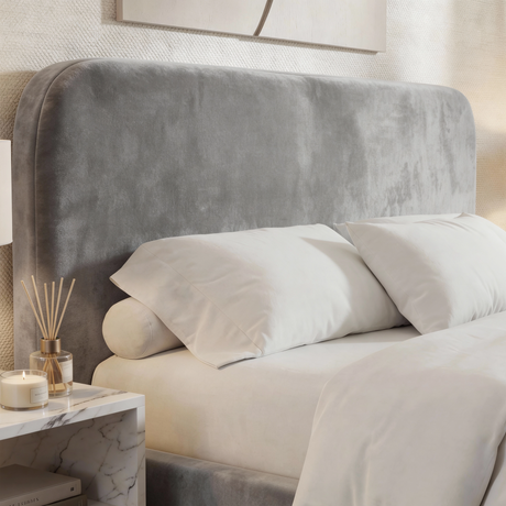 Close view of light grey upholstered small double bed headboard with curved shape and soft velvet fabric finish