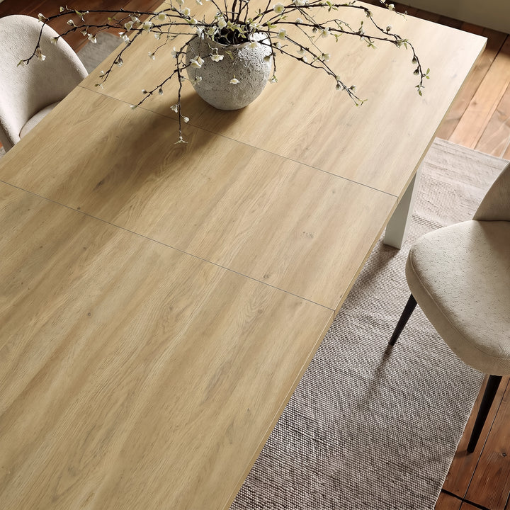 [140cm | Light Oak] 180cm extended Hartley dining table top with 40cm centre leaf, light light-oak grain, cream chairs and blossom vase.