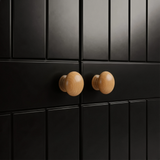[Black] Close-up of black brass round knob on Linra wardrobe drawer front showing grooved panel below