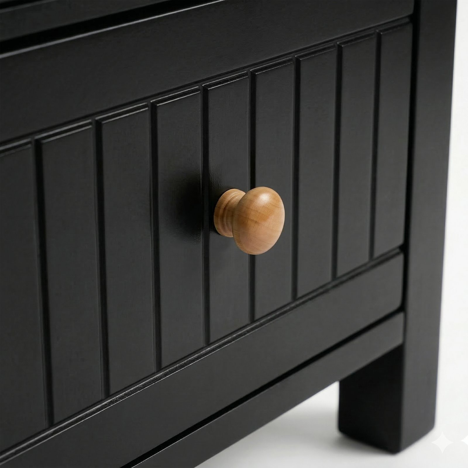 [Black] Detail of the Linra bedside table painted drawer with vertical groove lines and a natural wood pull knob