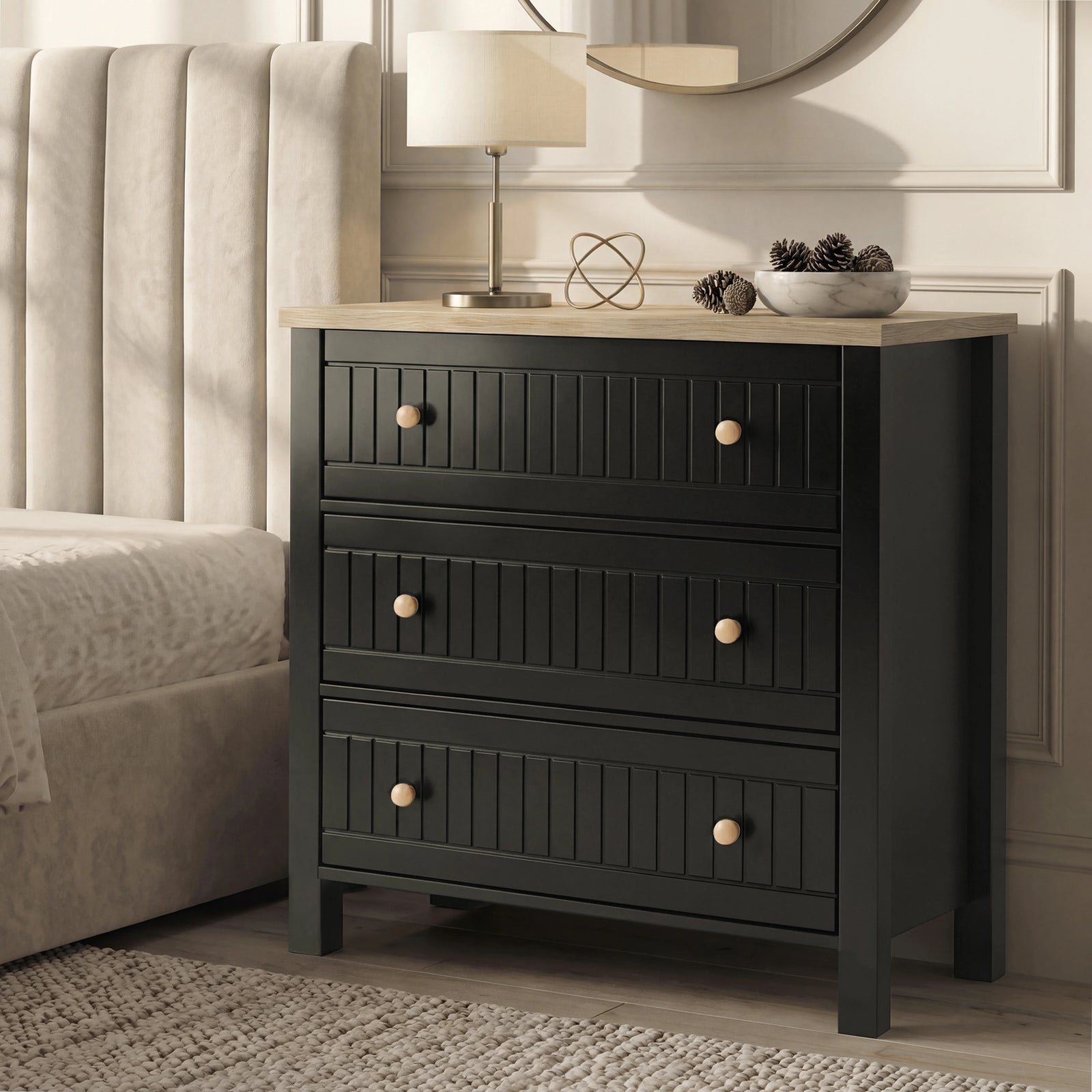 [Black] Linra chest of drawers in black at side of panelled bedroom wall, lamp and pinecones on oak top