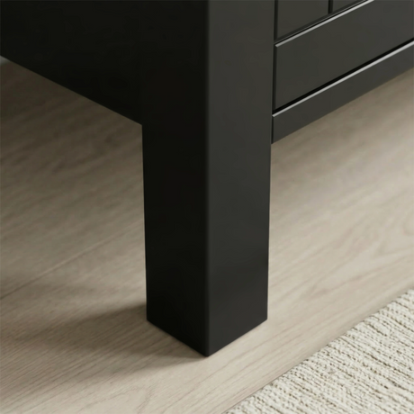 [Black] Linra 4-drawer chest angled close-up of painted frame leg base corner showing beaded panel door detail