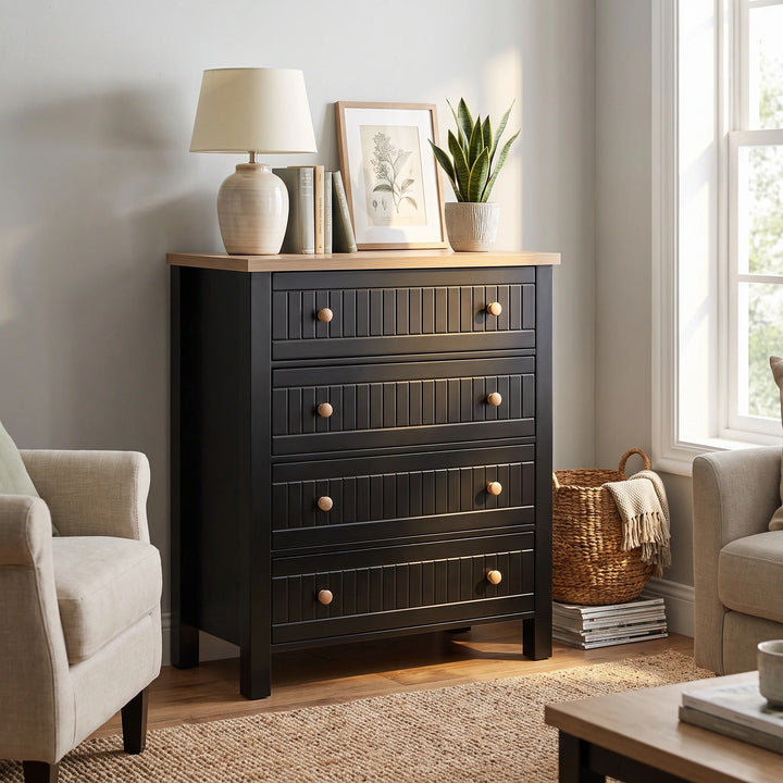 [Black] Linra 4-drawer chest in a wider bedroom lifestyle setting with armchair and accessories on oak veneer top