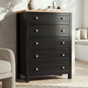 [Black] Linra 5-drawer chest front view in a styled room with armchair and vase arrangement on oak veneer top