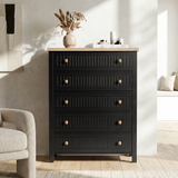 [Black] Linra 5-drawer chest front view in a neutral styled room with dried floral arrangement on oak veneer top