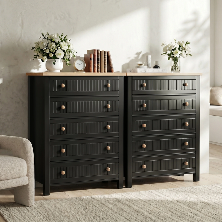 [Black] Pair of Linra 5-drawer chests styled side by side with white flowers, books and clock across both oak tops