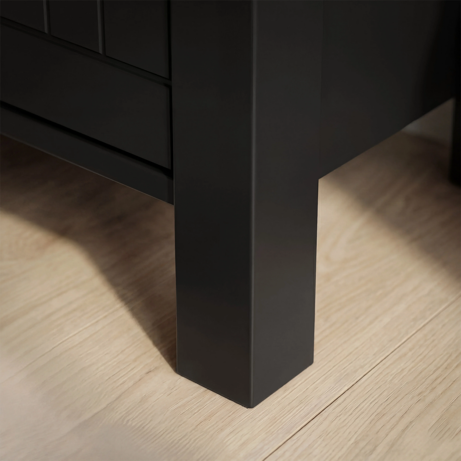 [Black] Linra 5-drawer chest base detail showing painted black square leg with grooved drawer above