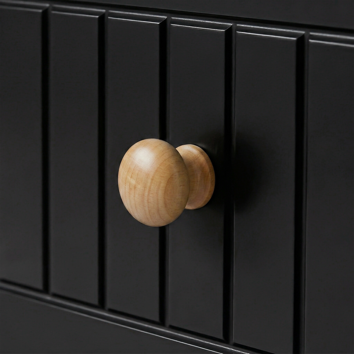 [Black] Close-up of Linra 5-drawer chest oak knob handle against fluted vertical slats on painted black drawer face