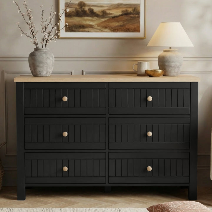 [Black] Linra 6-drawer chest front view in a styled room with neutral wall, lamp and artwork on the wall above