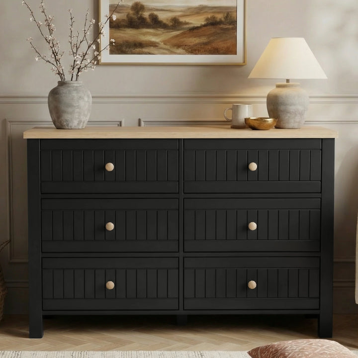 [Black] Linra 6-drawer chest front view in a styled room with neutral wall, lamp and artwork on the wall above