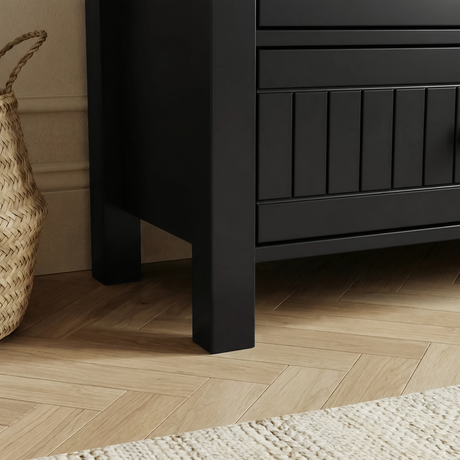 [Black] Linra 6-drawer chest angled close-up of the side panel showing painted frame leg base and beaded door detail