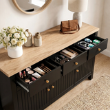 [Black] 3 door sideboard with open drawers containing various items, on a wooden floor with a rug