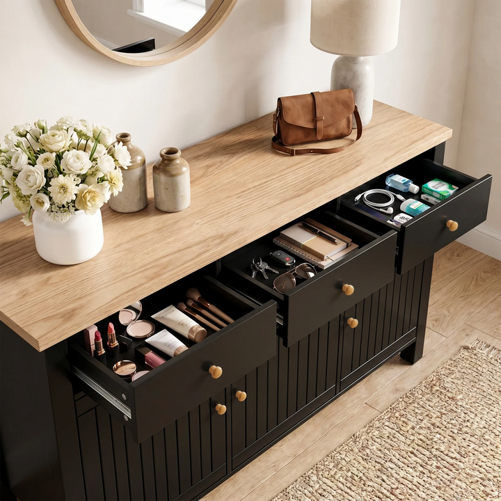 [Black] 3 door sideboard with open drawers containing various items, on a wooden floor with a rug