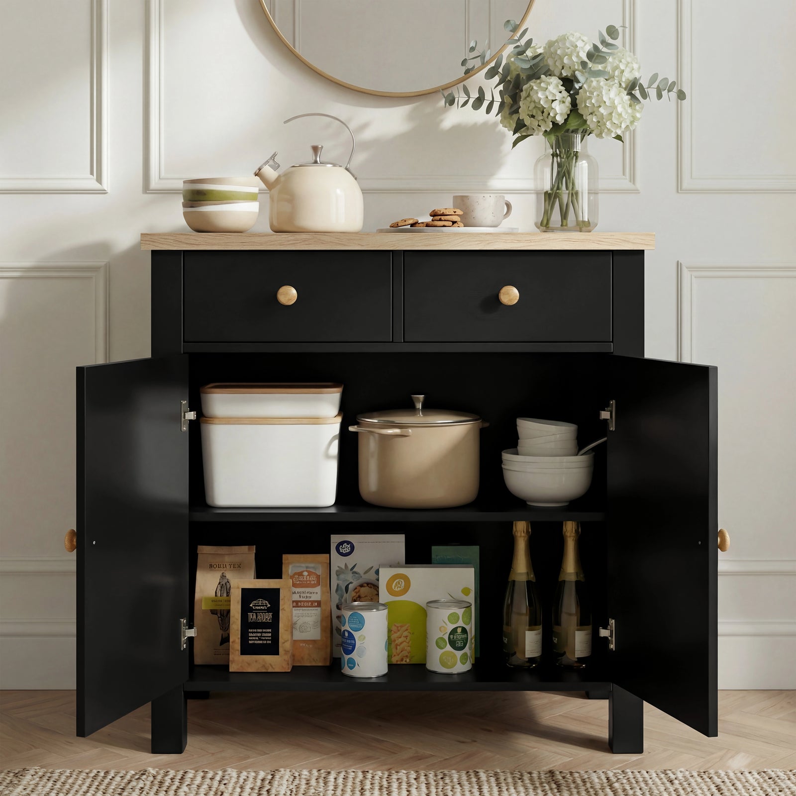 [Black] Linra sideboard interior loaded with kitchenware: kettle, pot, bowls above books and packets on lower shelf