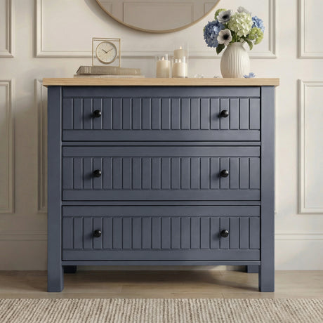 [Blue] Linra chest of drawers in panelled hallway beneath round wood-framed mirror with hydrangeas