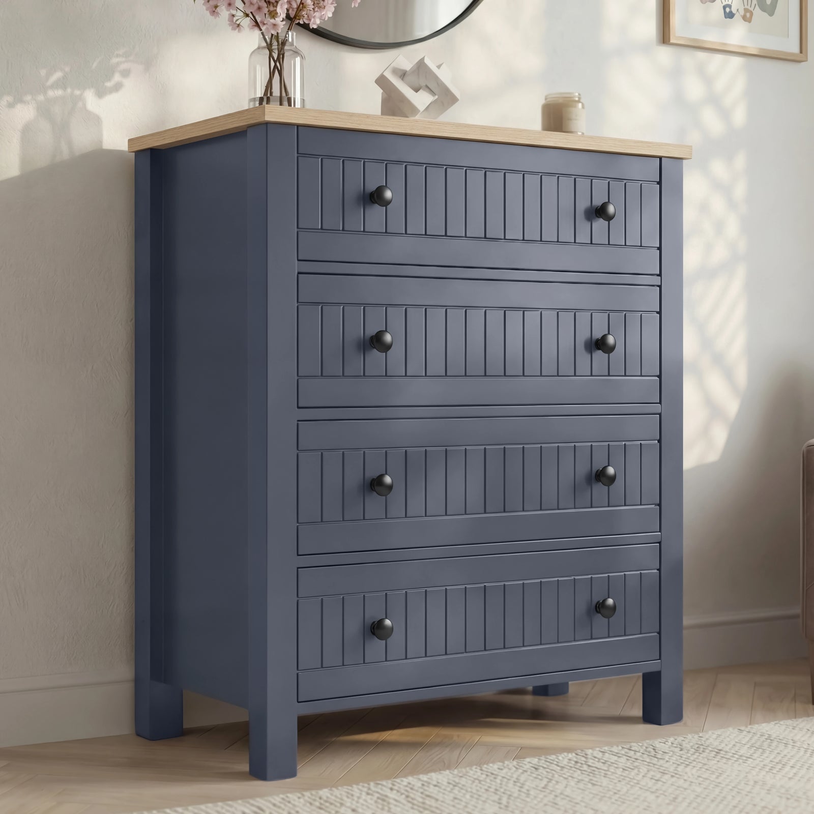 [Blue] Linra 4-drawer chest side angled view showing full height in a styled bedroom with mirror and books on top
