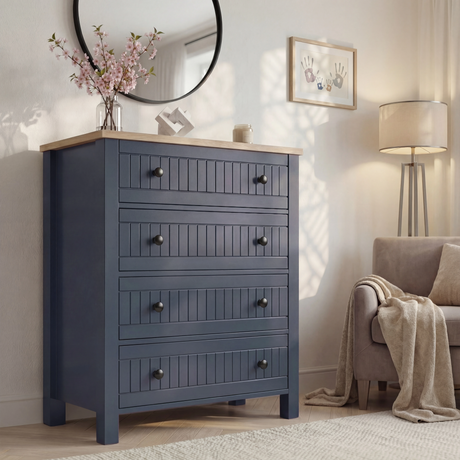 [Blue] Linra 4-drawer chest in a wider bedroom lifestyle shot with round mirror and accessories on oak veneer top