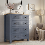[Blue] Linra 4-drawer chest in a wider bedroom lifestyle shot with round mirror and accessories on oak veneer top