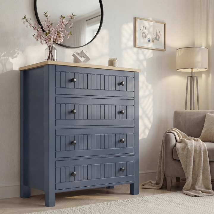 [Blue] Linra 4-drawer chest in a wider bedroom lifestyle shot with round mirror and accessories on oak veneer top