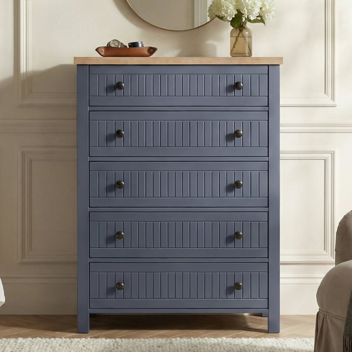 [Blue] Linra 5-drawer chest front view in a styled room with round mirror and accessories on oak veneer top