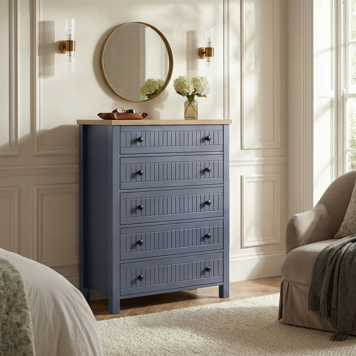 [Blue] Linra 5-drawer chest in a bedroom lifestyle setting with round mirror and accessories on oak veneer top