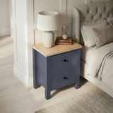 [Blue] Linra 2-drawer bedside table in a bedroom lifestyle setting with soft furnishings and lamp in background