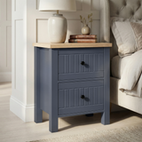 [Blue] Linra 2-drawer bedside table side view on plain background showing lamp, books, frame depth and oak top