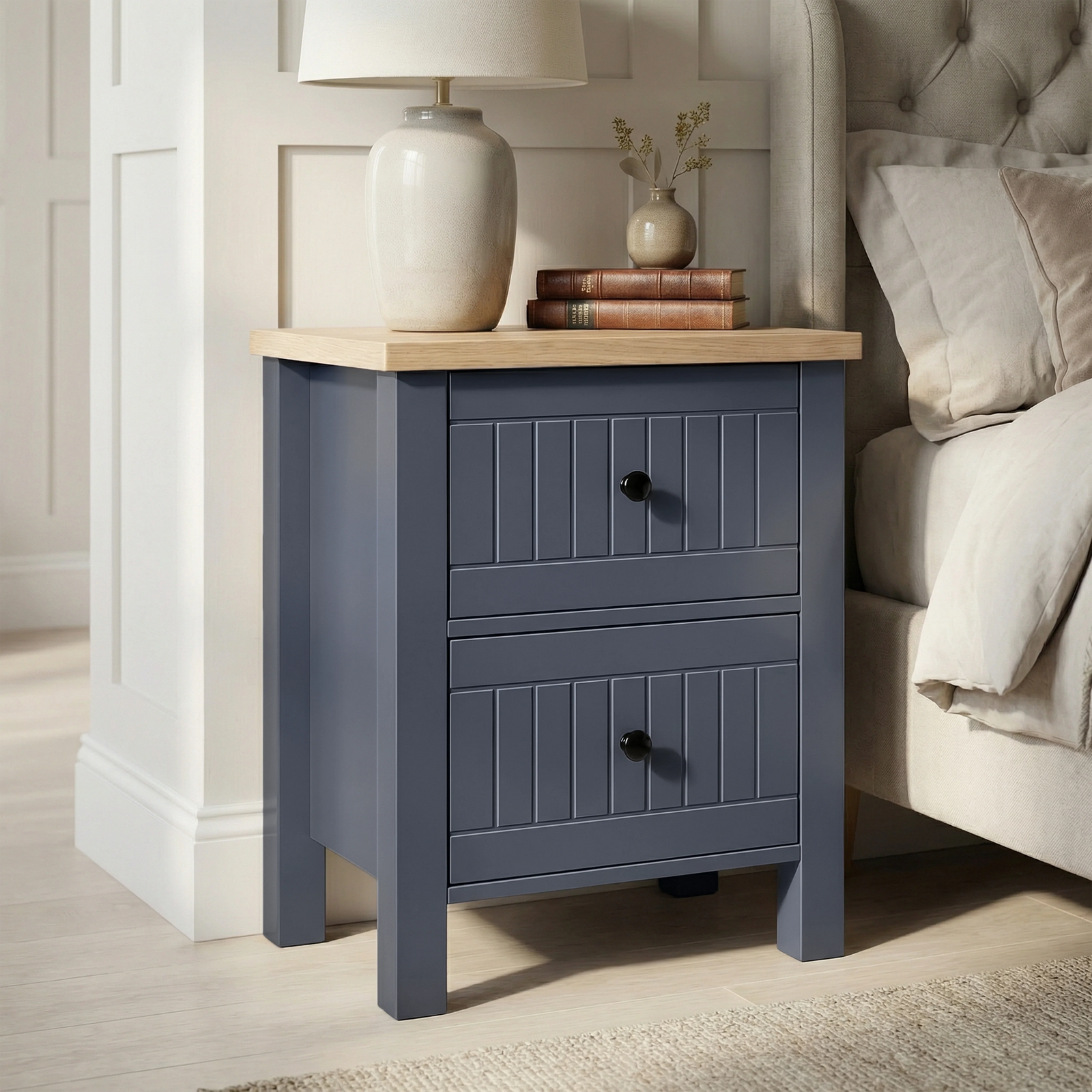 [Blue] Linra 2-drawer bedside table side view on plain background showing lamp, books, frame depth and oak top