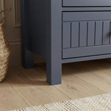 [Blue] Linra large 6 drawer chest leg detail with painted post meeting drawer rail above plank floor