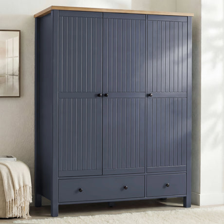 [Blue] Linra 3-door wardrobe side view in a bedroom showing closed doors, bar handles, and oak veneer top detail