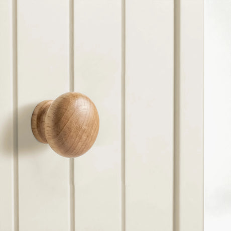 [White] Linra close-up detail of rounded oak wooden knob handle on beaded panel drawer front with painted finish visible