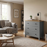 [Grey] Linra 3-drawer chest styled as living room storage beside a sofa, with black lamp, plant and books on the oak veneer top