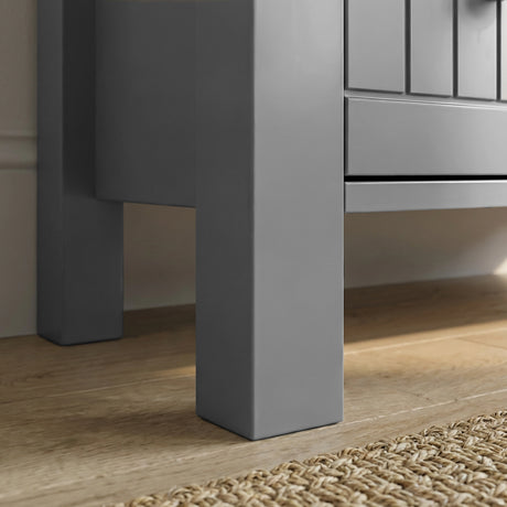 [Grey] Linra 3-drawer chest angled close-up of painted frame leg base corner showing beaded panel door detail