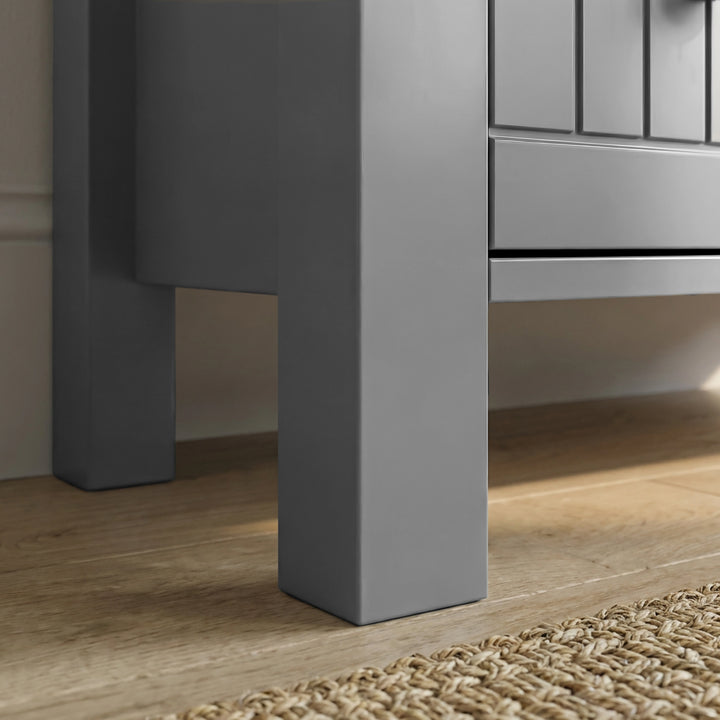 [Grey] Linra 3-drawer chest angled close-up of painted frame leg base corner showing beaded panel door detail