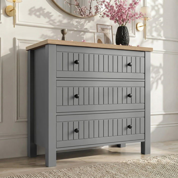 [Grey] Linra 3-drawer chest main front view with vase and decorative objects arranged on oak veneer top