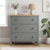 [Grey] Linra 3-drawer chest front view in a styled room with round mirror and decorative objects on oak veneer top