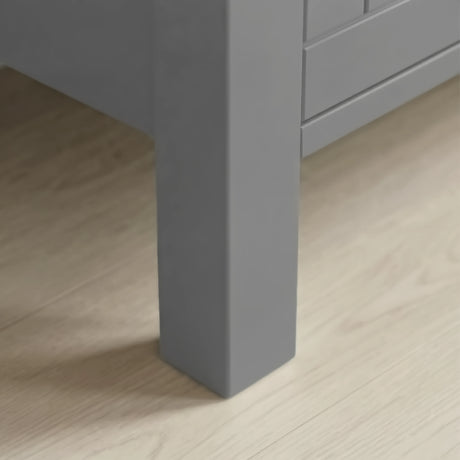 [Grey] Linra 4-drawer chest side angled view showing full height in a styled bedroom with mirror and books on top