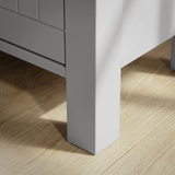 [Grey] Linra tall chest of drawers close-up of tapered square painted leg and base corner on oak flooring
