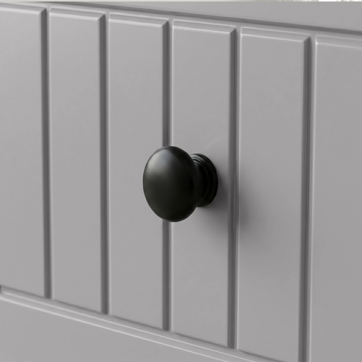 [Grey] Linra 5-drawer chest close-up of round solid black knob handle on a beaded panel painted drawer front