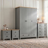 [Grey] Four piece Linra bedroom furniture set staged with woven rug, lamp and dried stems against panelled wall