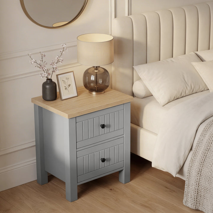 [Grey] Linra 2-drawer bedside table in a bedroom lifestyle setting with soft furnishings and lamp in background