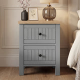[Grey] Linra 2-drawer bedside table front view in a styled bedroom setting with decorative accessories on top
