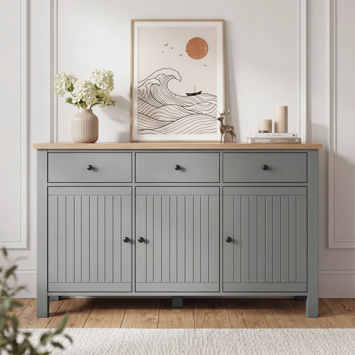 [Grey] Linra 135cm sideboard angled view in a styled room with framed artwork and vase on oak veneer top