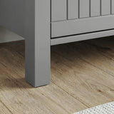 Linra sideboard foot close-up: grey tapered leg on oak floor with grooved panel edge above