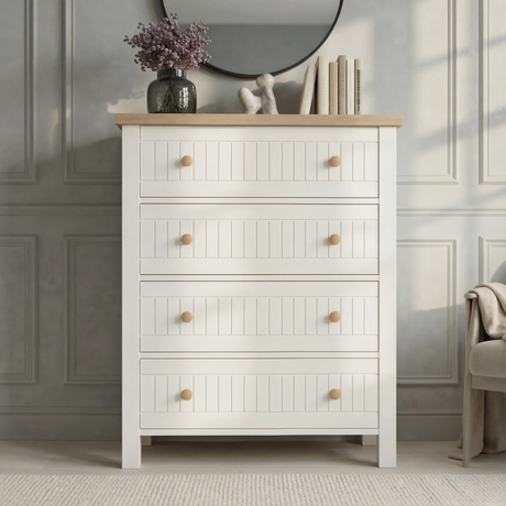 [White] Linra 4-drawer chest front view on plain background with vase and books arranged on oak veneer top