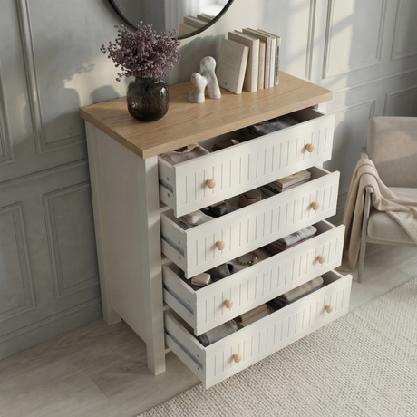 [White] Linra 4-drawer chest with all drawers open in a styled room with round mirror and vase on oak top