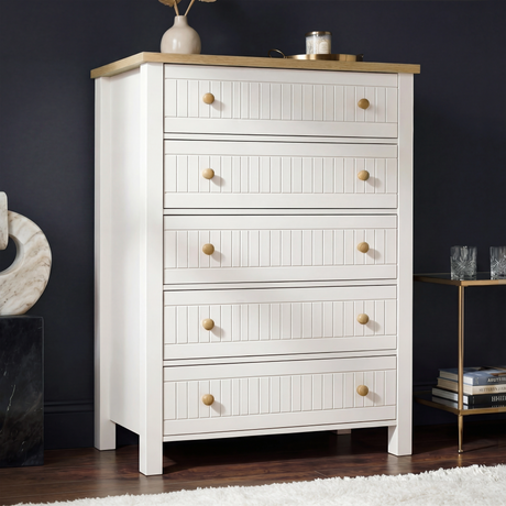 [White] Linra 5-drawer chest main front view against dark wall with vase and accessories on oak veneer top