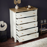 [White] Linra 5-drawer chest with drawers open in a styled room with dark wall and vase on oak veneer top