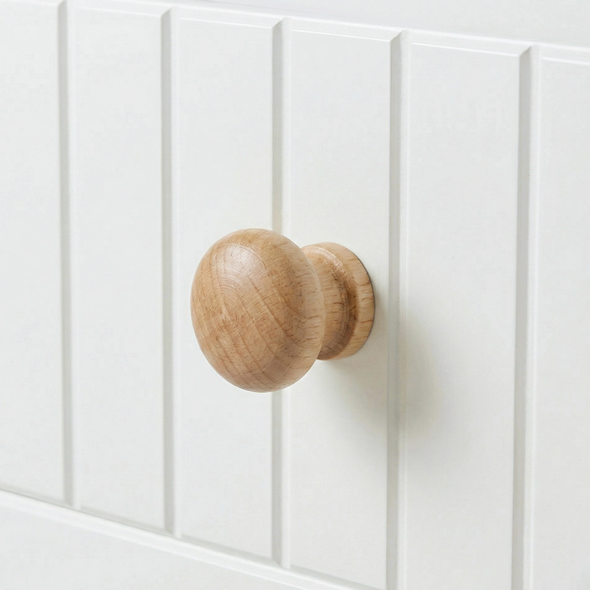 [White] Linra 5-drawer chest close-up of round solid oak knob handle on a beaded panel painted drawer front
