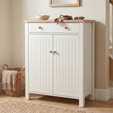 [White] Linra White 4 Tier Shoe Storage Cabinet front-facing with both beadboard doors closed alongside woven basket with throw blanket and staircase in background